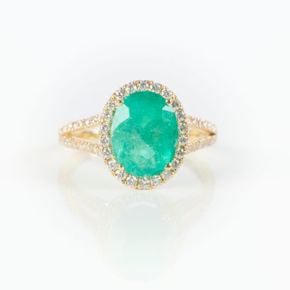 Gold ring (750‰), set with an oval-cut Colombian...