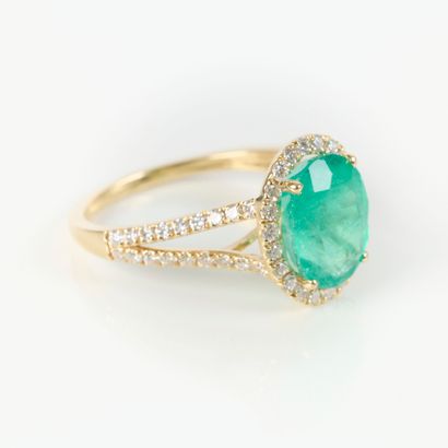 Gold ring (750‰), set with an oval-cut Colombian...