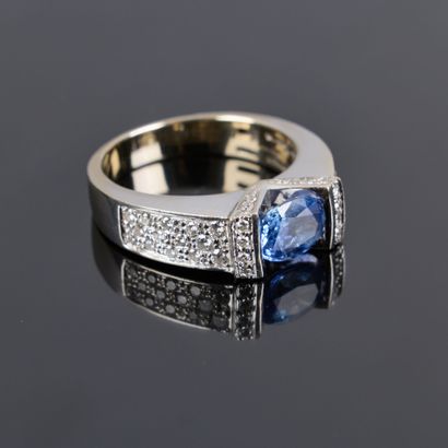 Gold ring set with an oval sapphire weighing...