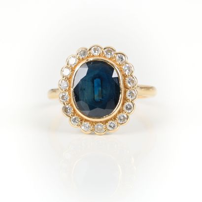 Gold ring set with an oval sapphire weighing...