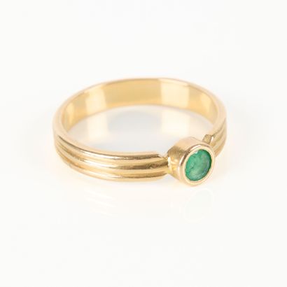 Gold solitaire ring set with a round emerald....
