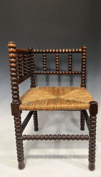 Fauteuil d'angle dit de coin de feu en bois
tourné.
Assise...