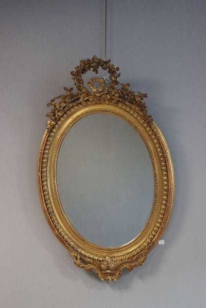 Miroir ovale doré
à décor de couronne de...