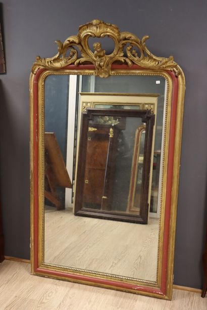 Large mirror in carved gilded wood with red...