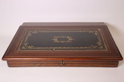 A veneered wooden writing desk with light-colored...