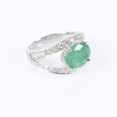 White gold ring set with an oval-cut emerald...