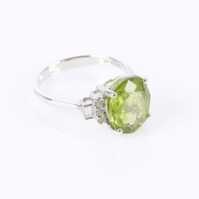 White gold ring set with an oval-cut peridot...