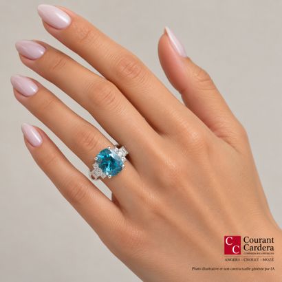 White gold ring set with a cushion-cut blue...