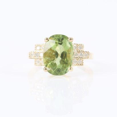 Gold ring set with an oval-cut green tourmaline...