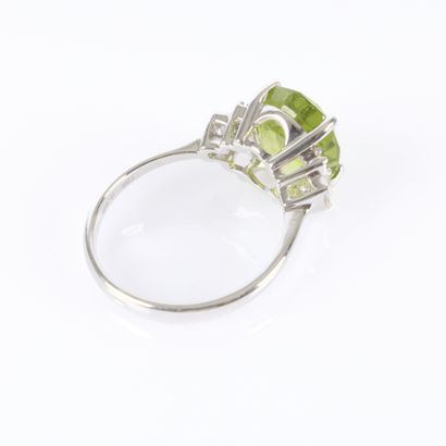 White gold ring set with an oval-cut peridot...