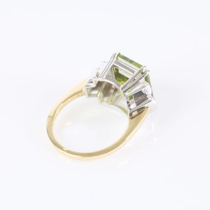 Two-tone gold ring set with an emerald-cut...