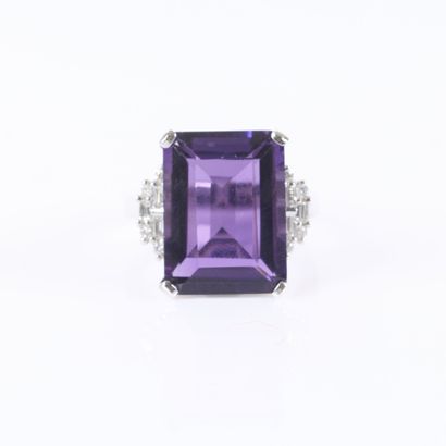 Stunning white gold ring set with an emerald-cut...