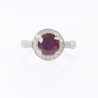 White gold ring set with a round ruby surrounded...