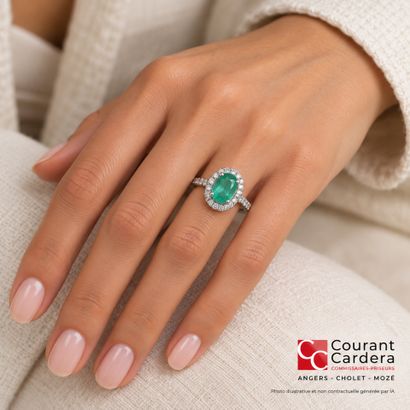 White gold ring set with an oval-cut emerald...