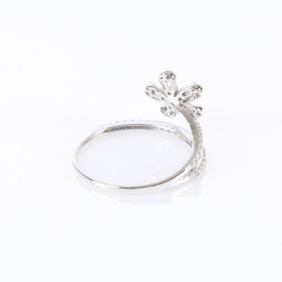 A delicate white gold ring featuring a row...