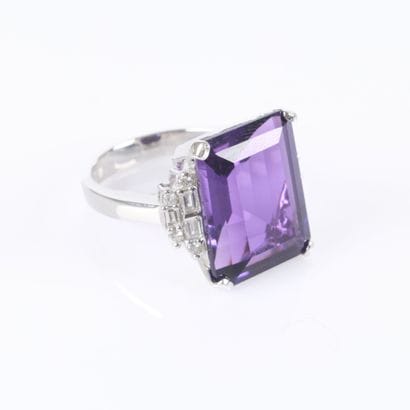 Stunning white gold ring set with an emerald-cut...