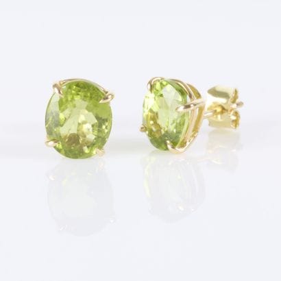 Pair of gold earrings, each set with an oval-cut...