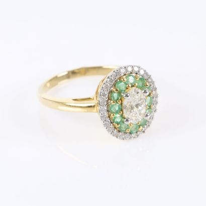 Gold ring set with an oval-cut diamond weighing...