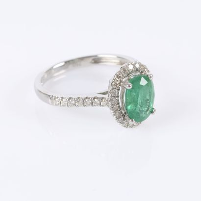 White gold ring set with an oval-cut emerald...