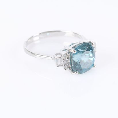 White gold ring set with a cushion-cut blue...