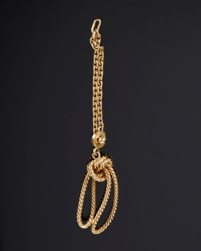 Gold keychain with a bow motif, attached...