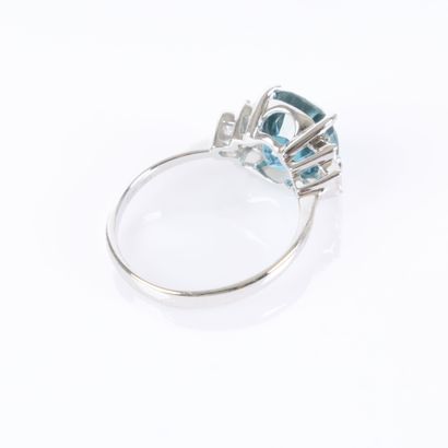 White gold ring set with a cushion-cut blue...