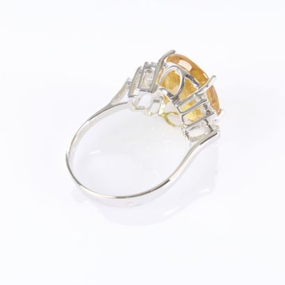 White gold ring set with an oval-cut yellow...