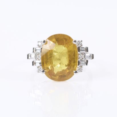 White gold ring set with an oval-cut yellow...