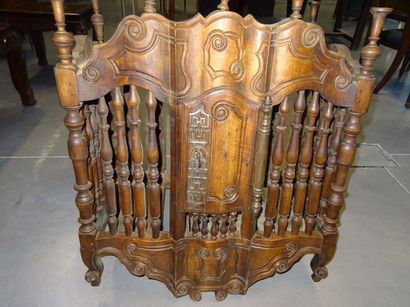 Pannetière en noyer mouluré à décor d'enroulements....