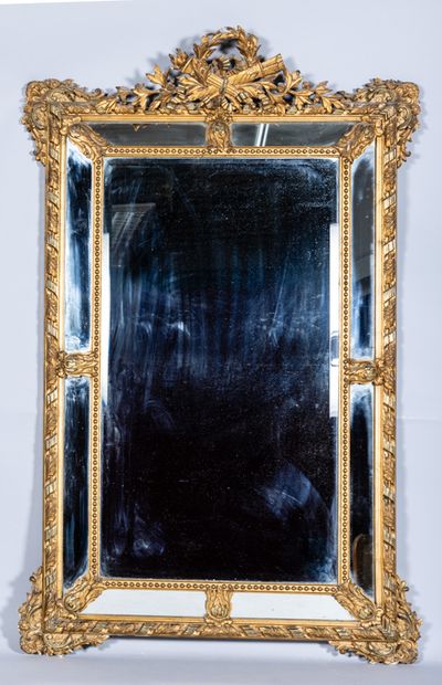 Grand miroir à parecloses en stuc doré surmonté...