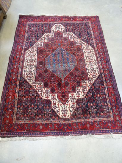 SENNEH: Tapis en laine à décor d'un médaillon...