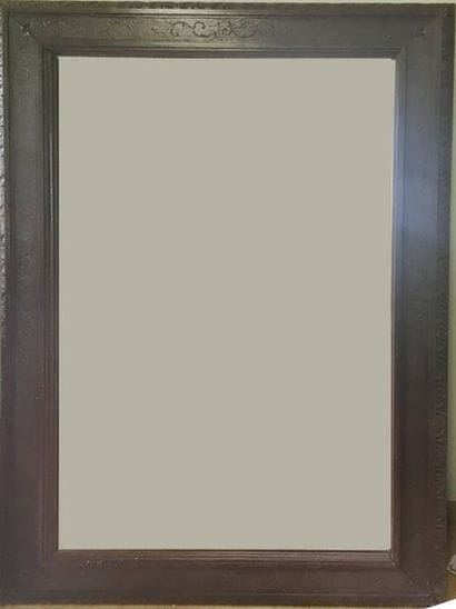 Grand miroir en bois teinté et sculpté à...