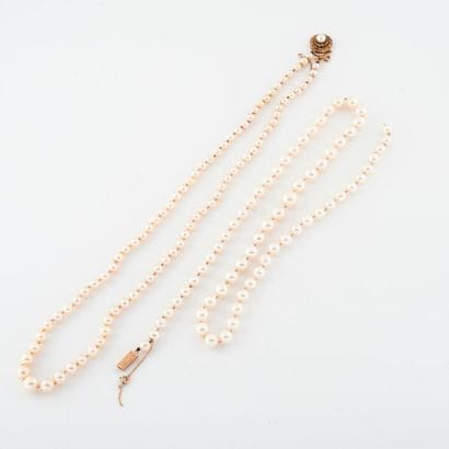 Two white cultured pearl necklaces falling...