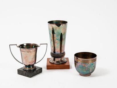 Three silver metal price cups:

- a high...