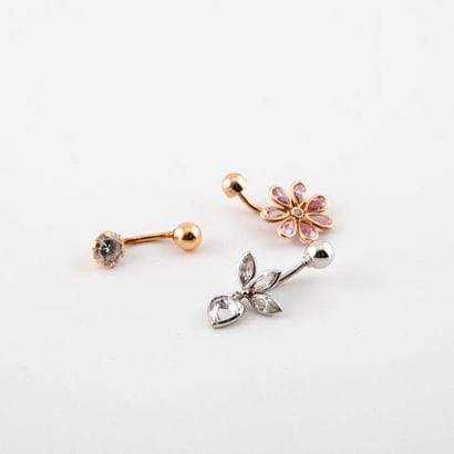 Two belly button piercings in yellow or white...
