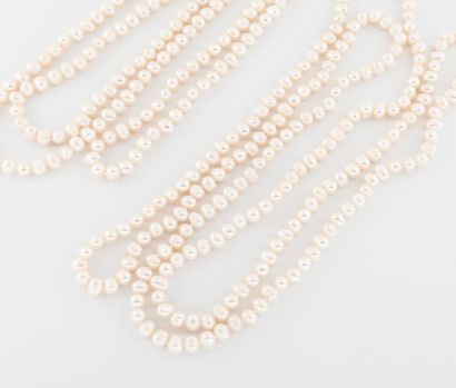 Deux colliers sautoirs de perles blanches...