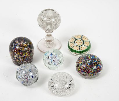 Set of seven glass paperweights, one on pedestal....