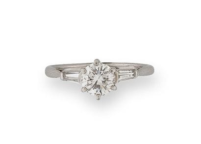 
A platinum (850) solitaire ring centered...