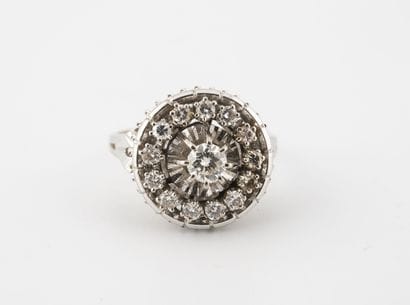 A white gold (750) ring centered and punctuated...