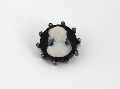 Circular brooch set with a cameo on white...