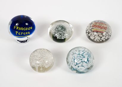 Quatre boules presse-papiers en verre incolore...
