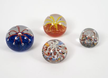 Quatre boules presse-papiers en verre incolore...