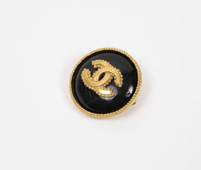 CHANEL
Broche ronde en métal doré et résine...
