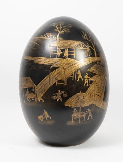 Ceramic egg painted in gold on a black background,...