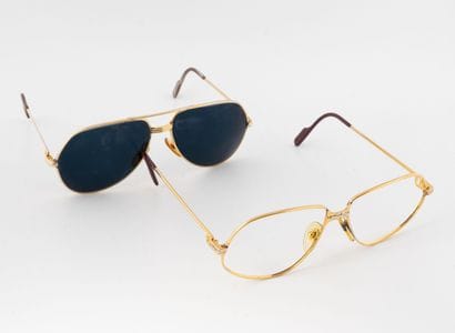MUST de CARTIER
Two pairs of glasses in gilded...