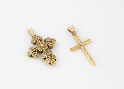 Deux croix en or jaune (750). Une en or filigrané,...