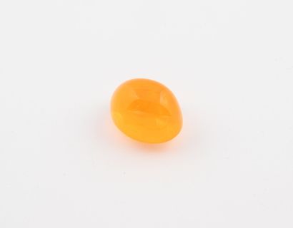 Cabochon d'une opale orange sur papier. 
Poids...