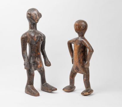 Two wooden sculptures of a man and a woman....