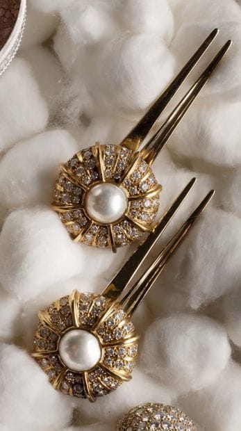 Two bun pins in yellow gold (750), the dome-shaped...