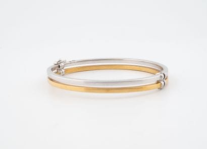 Bracelet jonc en or jaune et blanc (750).
Huit...